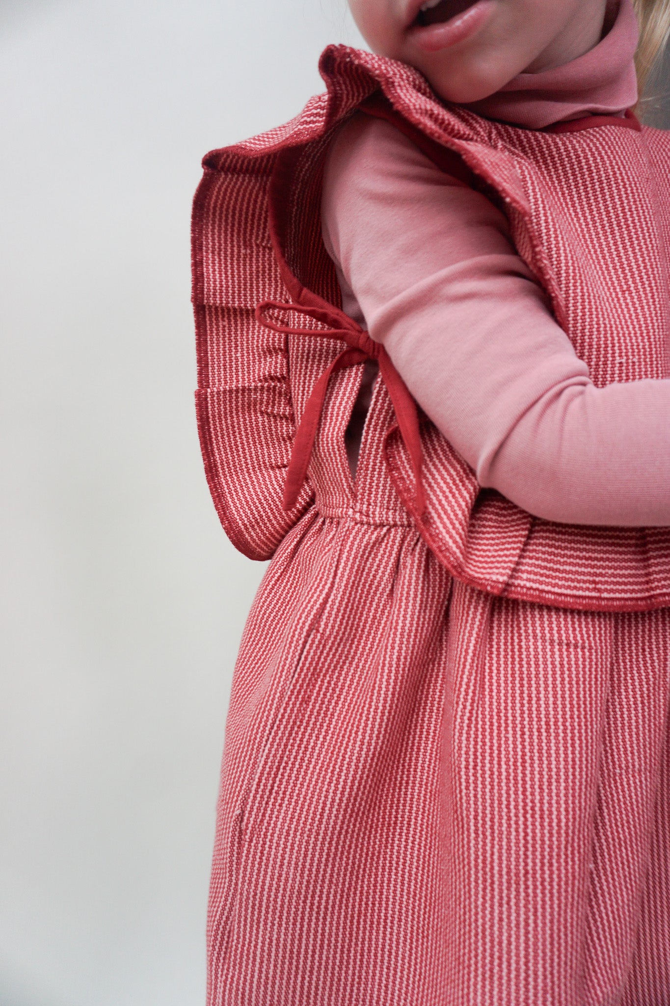 Blue and white striped dress with ruffled details on a white background