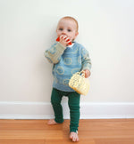 Load image into Gallery viewer, toddler wearing smiley jacquard knit sweater made from silk, mohair and alpaca and green organic cotton rib leggings
