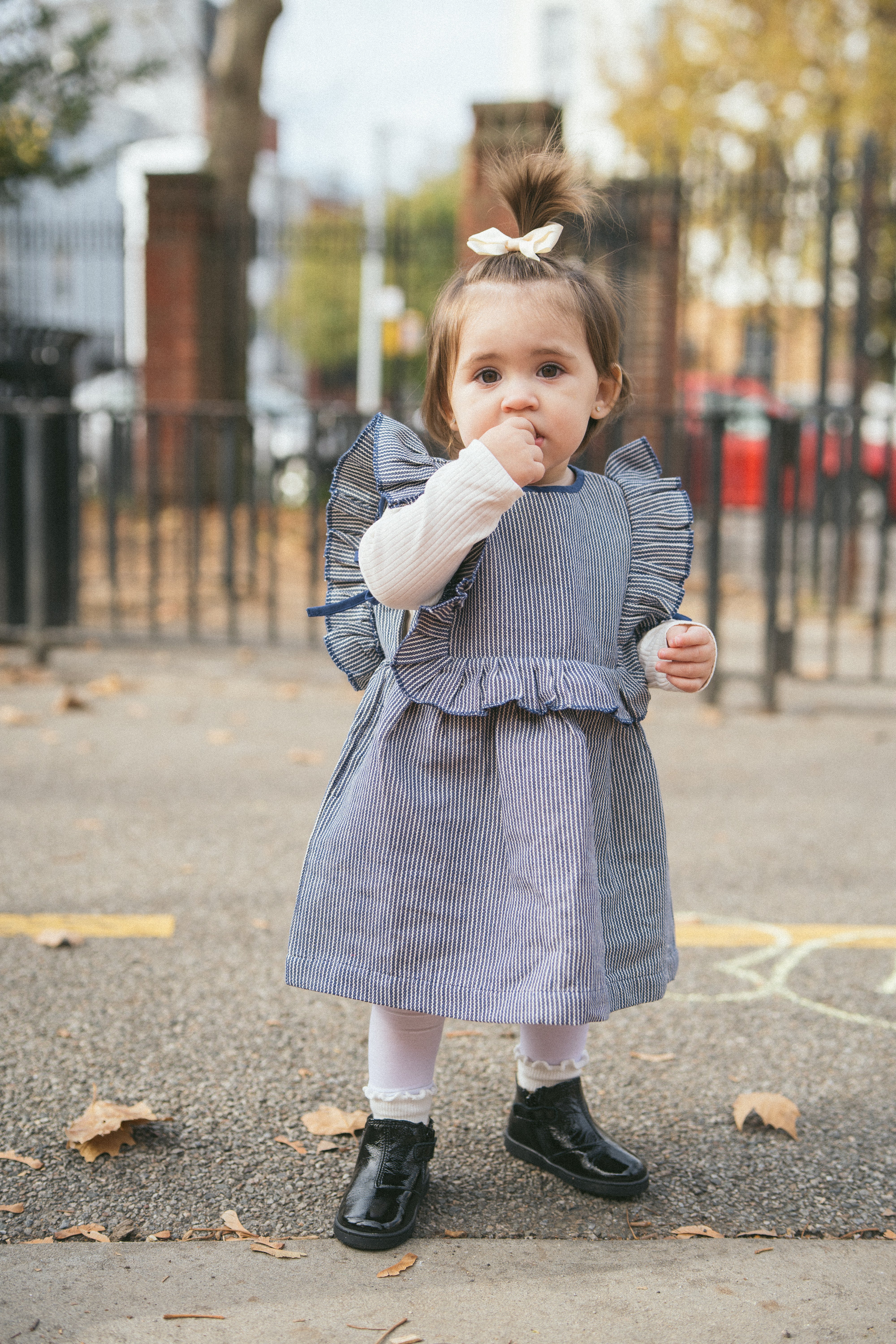 Blue and white striped dress with ruffled details on a white background