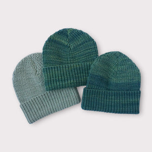photo of three green knit beanie hats
