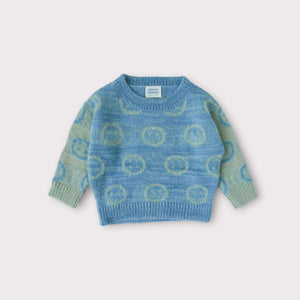 smiley face jacquard sweater laying flat and made from raw silk, kid mohair and alpaca