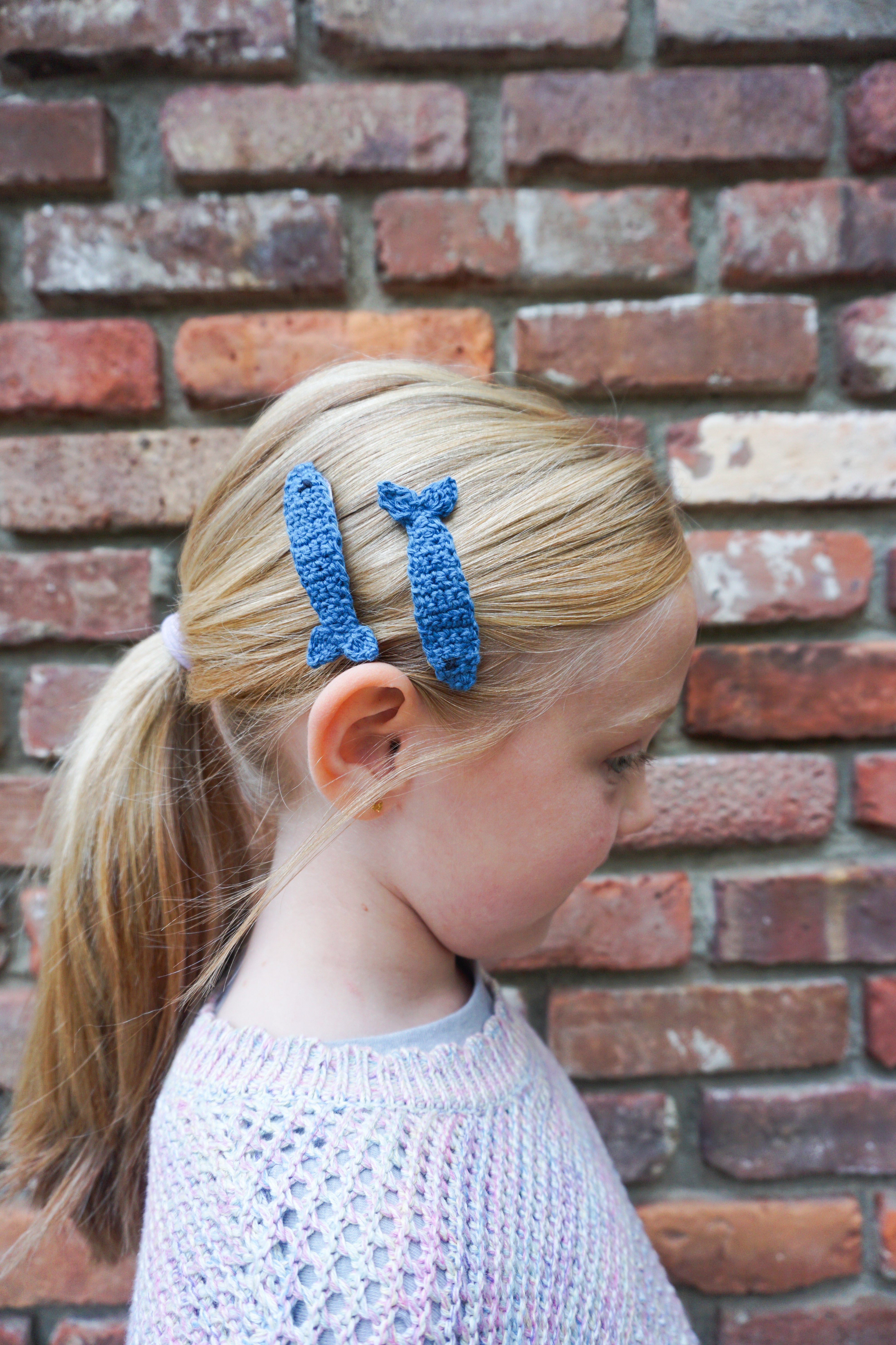 Girl wearing two blue sardine hair clips