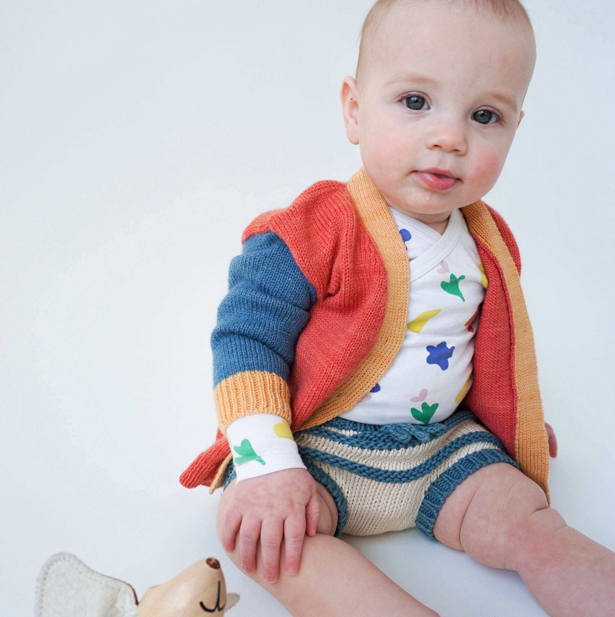 baby sitting wearing printed onsie, Colorblocked V-Neck Cardigan and striped cotton bloomer shorts