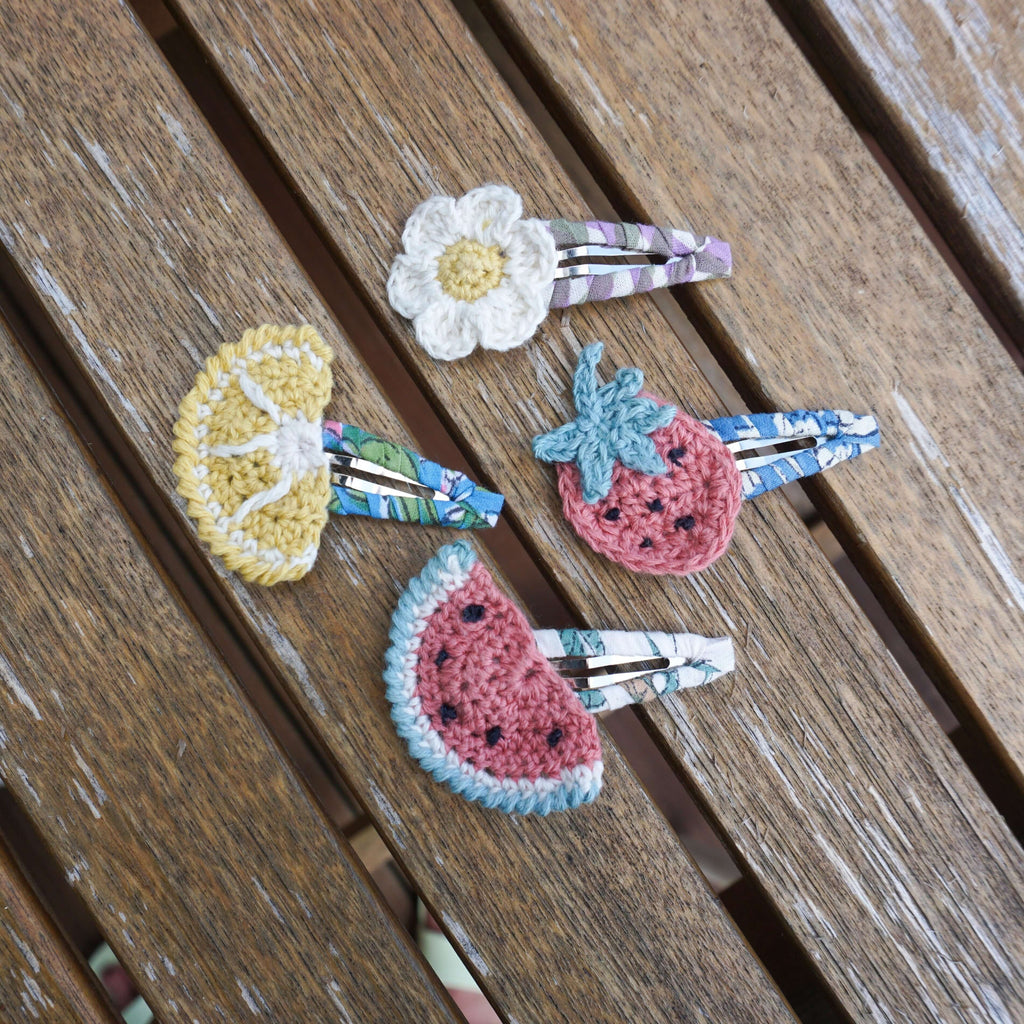 four clips with crochet fruit and flowers