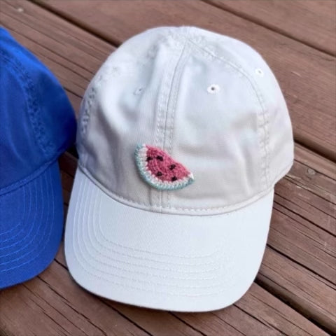 video of four hats with fruit appliques