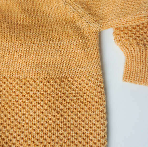 Close up view of yellow textured cardigan sweater